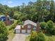 Aerial view of brick home featuring a two-car garage, a well-manicured lawn, and mature trees at 6608 Quiet Cove Ct, Raleigh, NC 27612