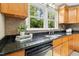 Gourmet kitchen with granite counters, stainless sink, and bright window with green view at 6608 Quiet Cove Ct, Raleigh, NC 27612