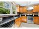Well-lit kitchen featuring stainless steel appliances, granite counters and a large window at 6608 Quiet Cove Ct, Raleigh, NC 27612