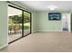 Bright, carpeted room featuring sliding glass doors to a patio and a mounted television at 6608 Quiet Cove Ct, Raleigh, NC 27612