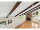 Bright living room features a brick fireplace, wood beams and hardwood flooring at 6608 Quiet Cove Ct, Raleigh, NC 27612