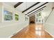 Bright living room with hardwood floors, beamed ceiling, brick fireplace, and plenty of natural light at 6608 Quiet Cove Ct, Raleigh, NC 27612