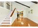 Open-concept living space with hardwood floors, staircase to the left, and a partial view of the kitchen at 6608 Quiet Cove Ct, Raleigh, NC 27612