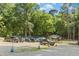 View of the parking area with several vehicles parked, with access to the community pool and wooded surroundings at 6608 Quiet Cove Ct, Raleigh, NC 27612