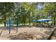 Community playground with slides, swings, and climbing equipment under a blue canopy in a park-like setting at 6608 Quiet Cove Ct, Raleigh, NC 27612