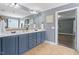 Bathroom features double sinks, blue cabinets, and an open entrance to the main bedroom at 6901 Rex Rd, Holly Springs, NC 27540