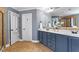 Bathroom with double sinks, dark blue cabinetry, and a walk-in shower at 6901 Rex Rd, Holly Springs, NC 27540