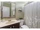 Bathroom featuring a large mirror, decorative wall art, and shower with patterned curtain at 6901 Rex Rd, Holly Springs, NC 27540