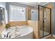 Bright bathroom features a soaking tub, glass block window, and separate shower at 6901 Rex Rd, Holly Springs, NC 27540