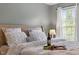Inviting bedroom featuring a plush bed, bedside lamp, and view of the outdoors at 6901 Rex Rd, Holly Springs, NC 27540