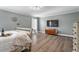 Spacious bedroom with hardwood floors, a flat-screen TV, and neutral wall decor at 6901 Rex Rd, Holly Springs, NC 27540