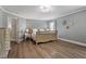 Bright bedroom featuring hardwood floors, light-grey walls, and a view of the hallway at 6901 Rex Rd, Holly Springs, NC 27540