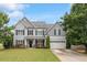 Charming two-story home with a well-manicured lawn, gray siding, and attached two car garage at 6901 Rex Rd, Holly Springs, NC 27540