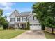 Charming two-story home with a well-manicured lawn, gray siding, and attached two car garage at 6901 Rex Rd, Holly Springs, NC 27540