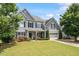 Charming two-story home with a well-manicured lawn, gray siding, and attached two car garage at 6901 Rex Rd, Holly Springs, NC 27540