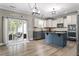 Modern kitchen with an island, stainless steel appliances, and a sliding glass door to the outdoor seating area at 6901 Rex Rd, Holly Springs, NC 27540