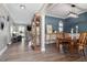 Open-concept space with hardwood floors, dining table, case, and arched entryways at 6901 Rex Rd, Holly Springs, NC 27540