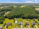 Expansive aerial view of a neighborhood surrounded by lush greenery, featuring homes with backyard pools at 6965 Ogburn Farms Dr, Willow Springs, NC 27592