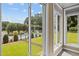 View of pool and manicured yard through sunroom windows, providing backyard access and natural light at 6965 Ogburn Farms Dr, Willow Springs, NC 27592