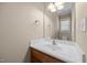 Bathroom featuring a wood vanity, white sink and faucet, and bright lighting at 6965 Ogburn Farms Dr, Willow Springs, NC 27592