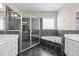 This bathroom features double sinks, a glass-enclosed shower, and a soaking tub with black tile surround at 6965 Ogburn Farms Dr, Willow Springs, NC 27592