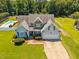 Charming home with light blue siding, stone accents, a well-manicured front yard and an in-ground pool at 6965 Ogburn Farms Dr, Willow Springs, NC 27592