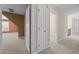 Hallway with neutral walls and carpeting, featuring multiple doors and natural light at 6965 Ogburn Farms Dr, Willow Springs, NC 27592