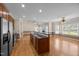 Spacious open layout kitchen with stainless steel refrigerator, kitchen island, and hardwood floors at 6965 Ogburn Farms Dr, Willow Springs, NC 27592