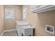 Clean laundry room featuring a utility sink, built-in cabinets, and great natural light at 6965 Ogburn Farms Dr, Willow Springs, NC 27592