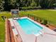 Aerial view of a private in-ground pool with a slide, seating, and fenced yard at 6965 Ogburn Farms Dr, Willow Springs, NC 27592