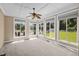 Bright sunroom featuring a ceiling fan, large windows and view of the pool and manicured backyard at 6965 Ogburn Farms Dr, Willow Springs, NC 27592