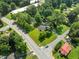 Aerial view of the property showing the house, detached garage, and surrounding lush greenery at 703 Whitsett Ave, Gibsonville, NC 27249