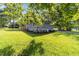 This backyard features mature trees and an outdoor porch at 703 Whitsett Ave, Gibsonville, NC 27249