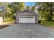 Detached two-car garage with white doors and gray siding, providing ample parking and storage space at 703 Whitsett Ave, Gibsonville, NC 27249