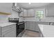 Modern kitchen with gray cabinets, white countertops, tile backsplash, and stainless steel appliances at 703 Whitsett Ave, Gibsonville, NC 27249