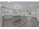 Open-concept kitchen featuring new gray cabinets, a center island, and stainless steel appliances at 703 Whitsett Ave, Gibsonville, NC 27249