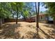 Backyard featuring mature trees, fresh mulch, and a wooden deck at 708 Parker St, Durham, NC 27701