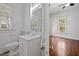 Bathroom with a sink, mirror, and window view from the doorway of an adjacent bedroom at 708 Parker St, Durham, NC 27701