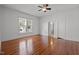 Spacious bedroom with hardwood floors, ceiling fan, a large window and a connecting bathroom at 708 Parker St, Durham, NC 27701