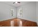 Bright bedroom featuring hardwood floors, two windows, and a ceiling fan at 708 Parker St, Durham, NC 27701