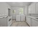 A bright kitchen with white appliances and plenty of cabinet space for storage and cooking at 708 Parker St, Durham, NC 27701