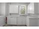 Kitchen featuring white cabinets, stainless steel sink and appliances near washer and dryer hookups at 708 Parker St, Durham, NC 27701