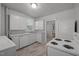 A bright kitchen with white cabinets and appliances including a stove and dishwasher at 708 Parker St, Durham, NC 27701