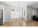 Bright dining room with hardwood floors, large windows with light curtains, and a modern chandelier at 733 Daniel Ridge Rd, Wendell, NC 27591