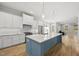 Spacious kitchen with a large center island, white cabinets, stainless steel appliances, and hardwood floors at 733 Daniel Ridge Rd, Wendell, NC 27591