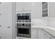 Close-up of stainless steel microwave and oven, with white cabinets and a tiled backsplash at 733 Daniel Ridge Rd, Wendell, NC 27591