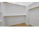 Spacious walk-in closet features wood flooring, white shelving, and neutral paint scheme at 733 Daniel Ridge Rd, Wendell, NC 27591