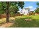 Grassy backyard featuring a privacy fence, mature trees, and a deck, creating a peaceful outdoor space at 741 Rockville Rd, Wake Forest, NC 27587
