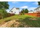 Fenced backyard with lush green grass, a mature tree, and a wooden deck at 741 Rockville Rd, Wake Forest, NC 27587