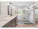 Modern bathroom with double sinks, marble countertops, and a glass shower with stone floor at 741 Rockville Rd, Wake Forest, NC 27587